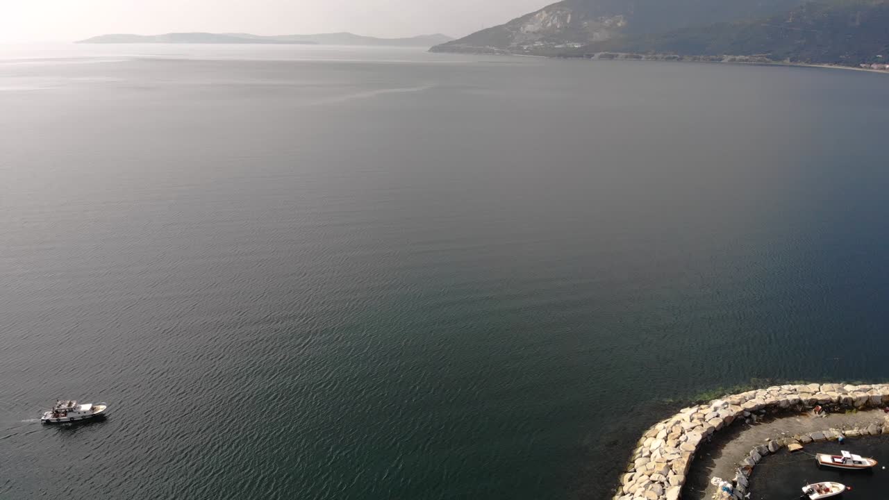 Aerial downward flight while the white boat is passing on the sea, Turkey