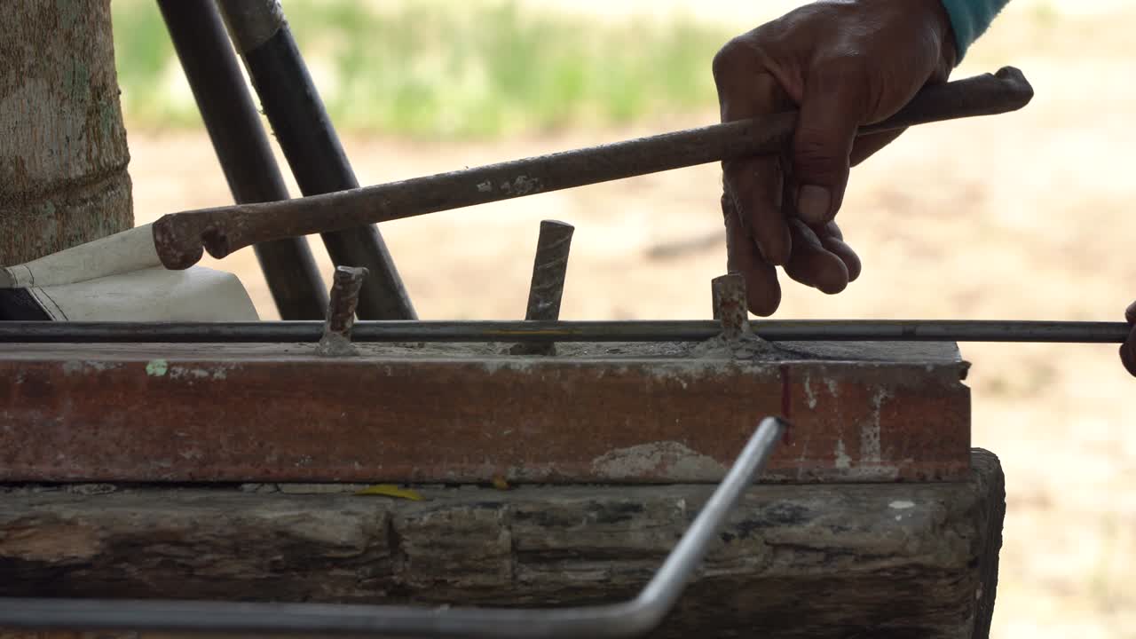 рабочий изгибает стальную линию в квадратную форму. к строительному зданию.