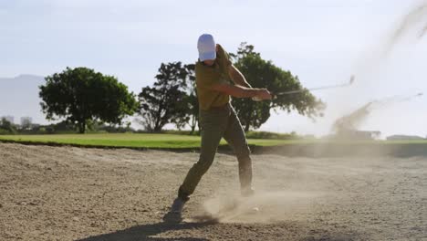 golf player hitting the ball with his club