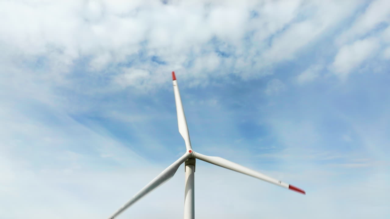 Aerial drone view of a wind turbine in a field on a cloudy day