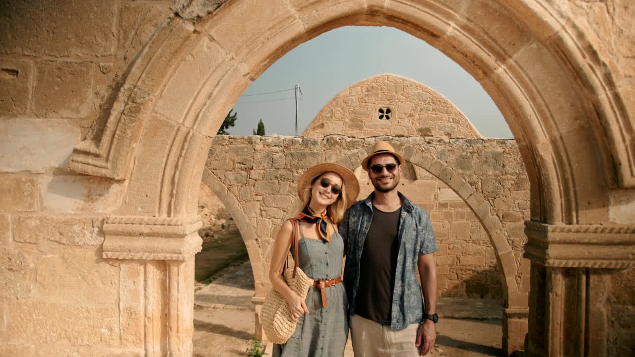 Turistpar på sightseeing ved en gammel steinkirke i Europa
