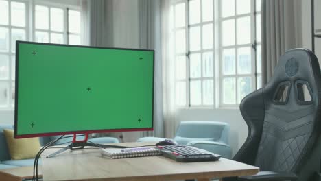 green screen desktop computer on a table with a chair in the working room at home.