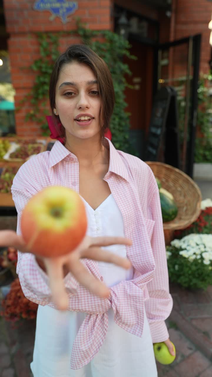 mujer ofreciendo manzana en un mercado