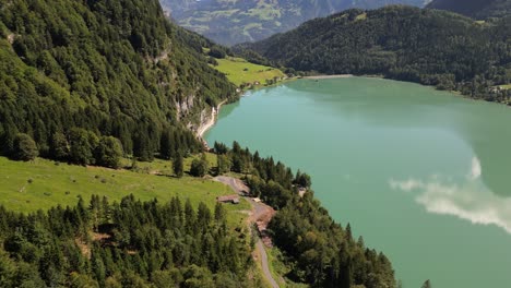 Majestic-Peaks,-Crystal-Waters:-Aerial-view-of-green-forest-and-Lakeside-Mountains