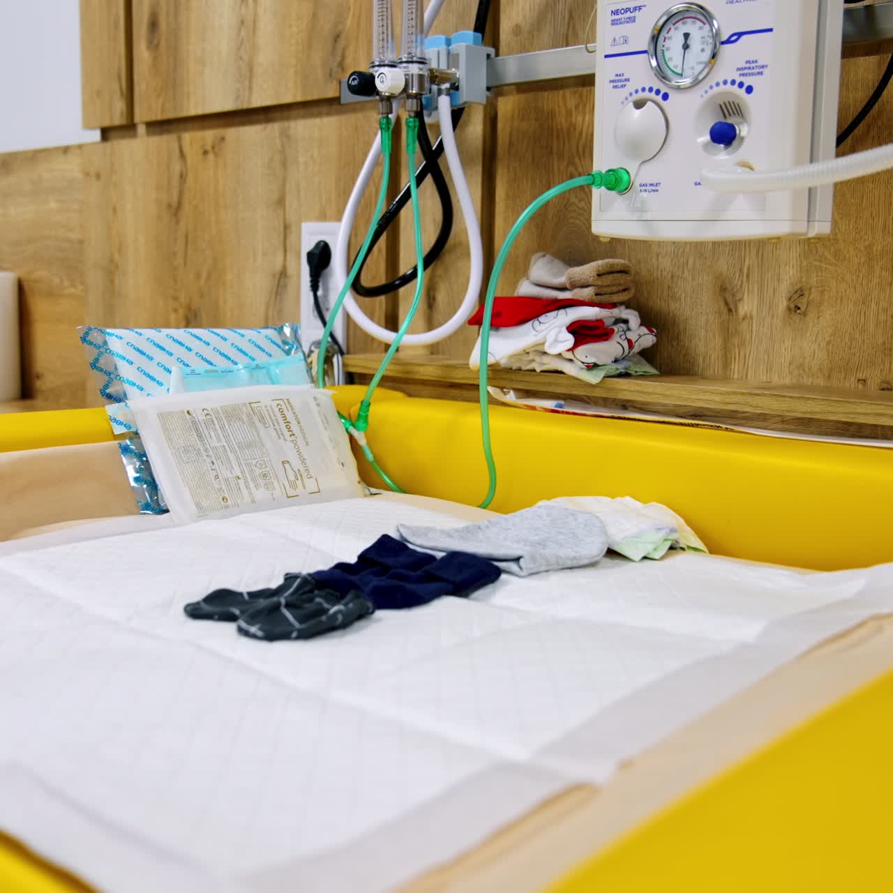 Resuscitation equipment attached to the wall over the table for newborns. Medical devices in the modern maternity hospital. Low angle view