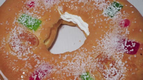 Roscon-de-Reyes-Pastry-with-Vanilla-Cream,-Closeup-Overhead-Tilt-Up