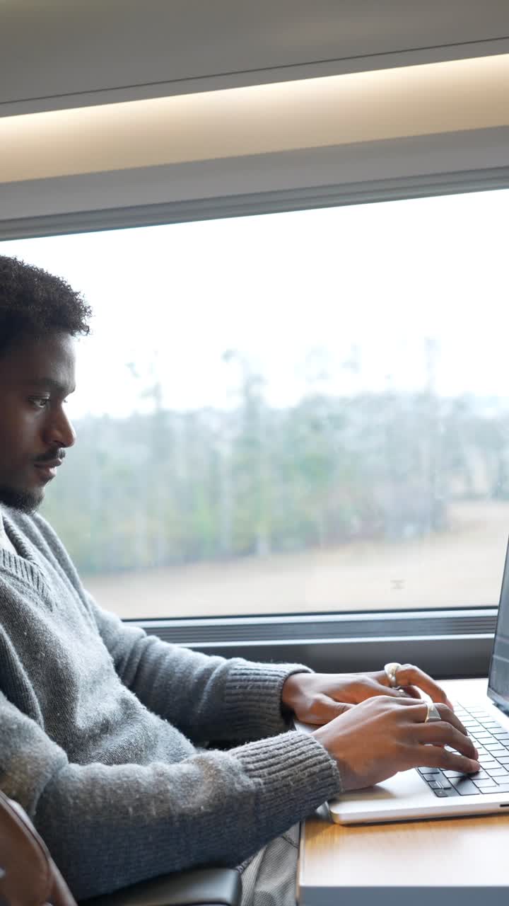 Man Working on Laptop While Traveling by Train