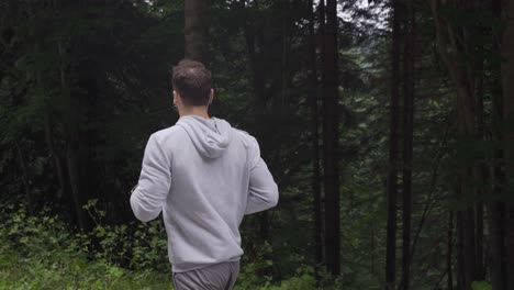 athlete man is jogging in the forest.