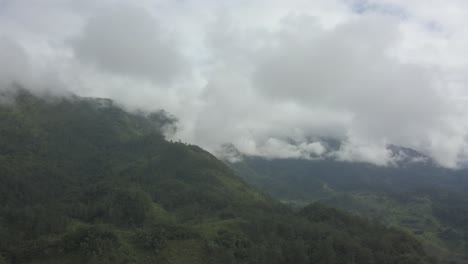 drone aerial hyperlapse flying over the mountains and a tropical landscape in guatemala during a cloudy day
