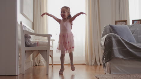 cute little girl dancing playfully pretending to be ballerina happy child having fun playing dress up wearing ballet costume with fairy wings at home 4k