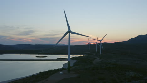 wind farm at sunset over a reservoir