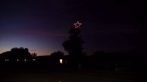 Large-Christmas-Star-on-Big-Tree-at-Night-by-Roadside-with-Car