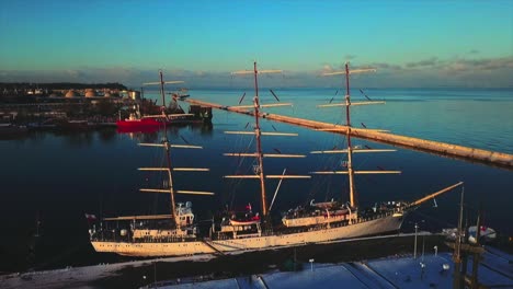 drone volando hacia atrás del barco al atardecer