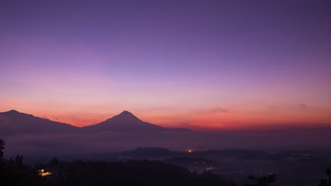 mount merapi sunrise with purple sky, sweeping clouds and swirling mist