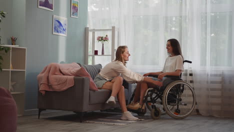 caring woman moves wheelchair with disabled girlfriend close