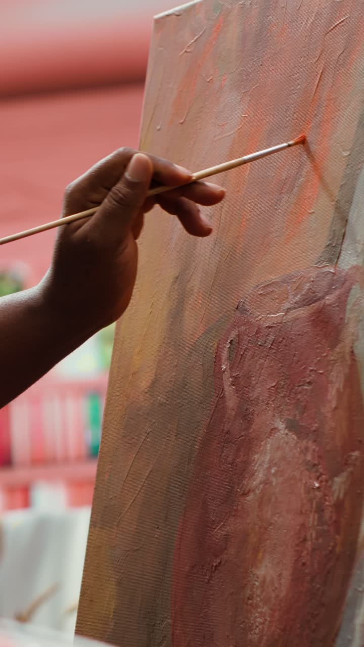 Close-up of Artist's Hand Painting on Canvas with Brush
