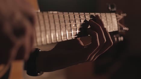 a handsome guy plays an acoustic guitar in an abandoned cinema. the musician sings a song and accompanies on the guitar