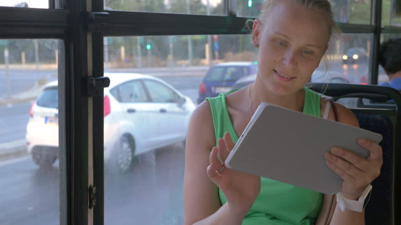 버스에서 태블릿을 사용하는 여성