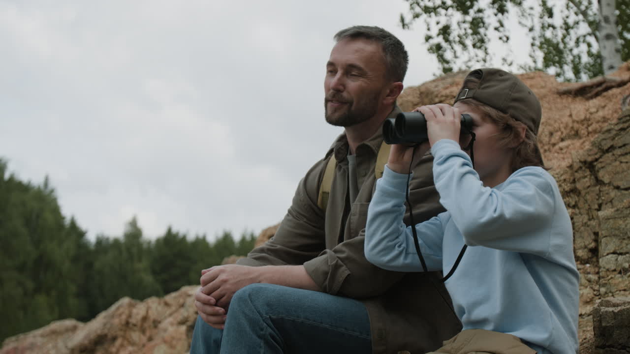 Father and son with binoculars outdoors