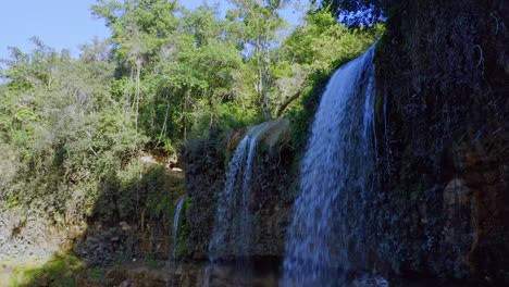 Schöne-Mittlere-Aufnahme-Mehrerer-Wasserfälle,-Umgeben-Von-Grüner-Waldlandschaft-Im-Sonnenlicht