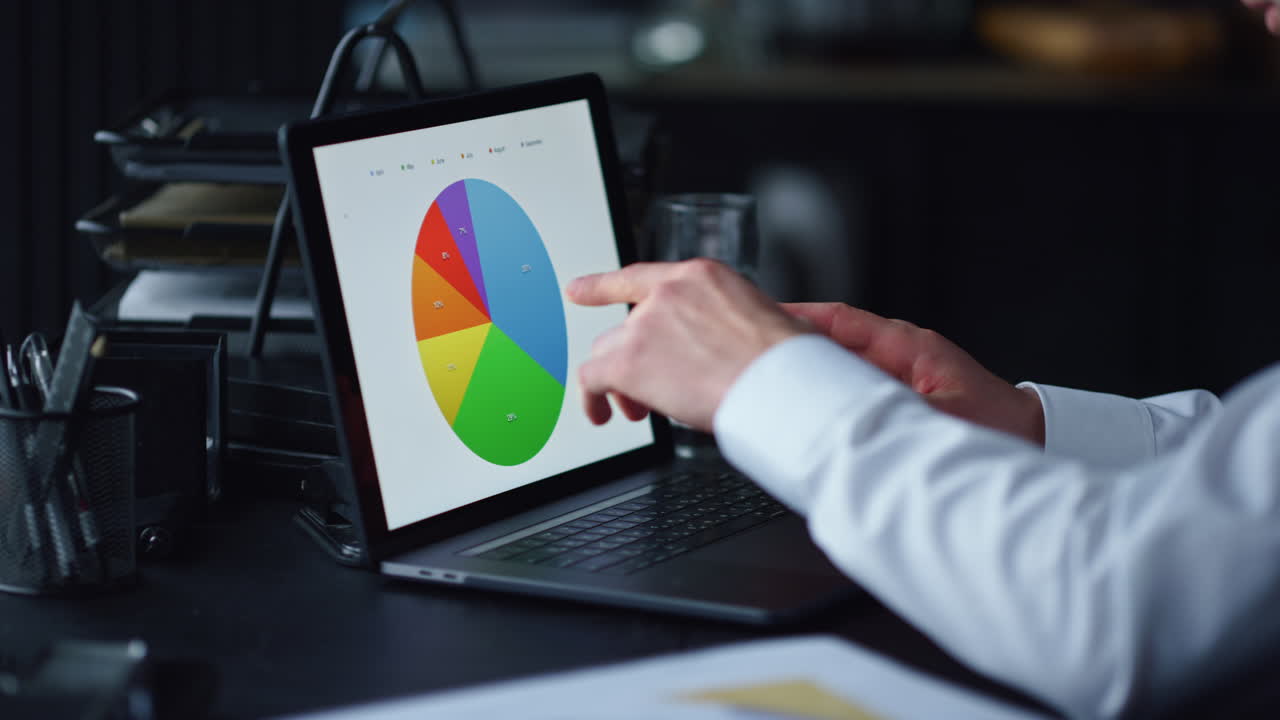 manos del hombre trabajando en la computadora portátil en la oficina. profesional señalando con el dedo en los gráficos