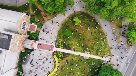 aerial top down view of huge crowd gathered outside the church on bright sunny day