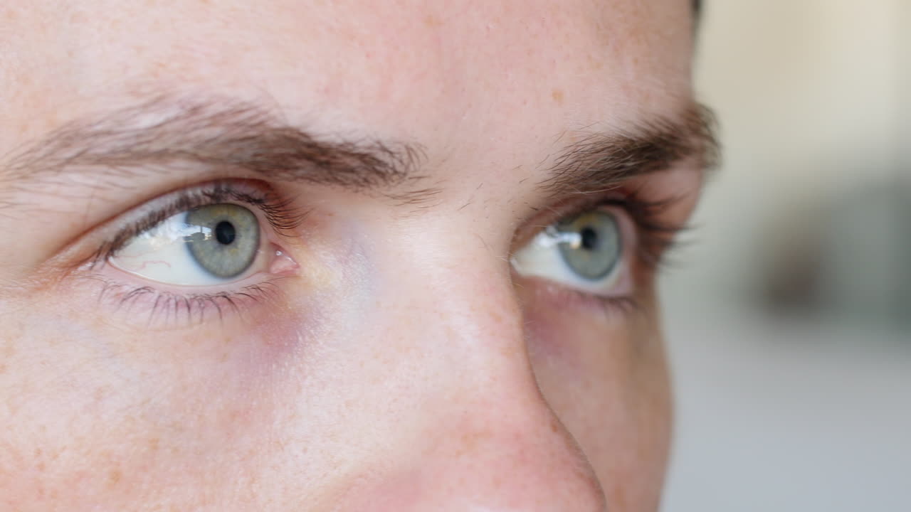 초점을 맞춘 파란 눈을 가진 카메라를 바라보는 남성, 간헐적으로 깜박임