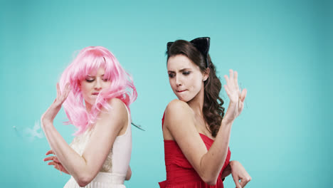 amigas bailando con vestido rojo y cabello rosa en la cabina de fotos de la fiesta en cámara lenta