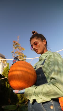 mujer cosechando calabazas