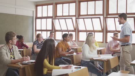 teacher speaking to students in high school class