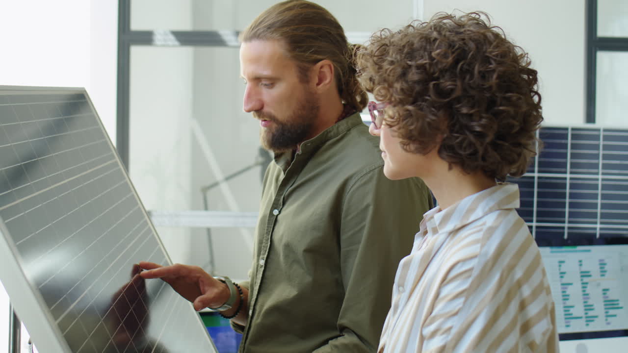 Renewable Energy Engineers Discussing Solar Panel in Office