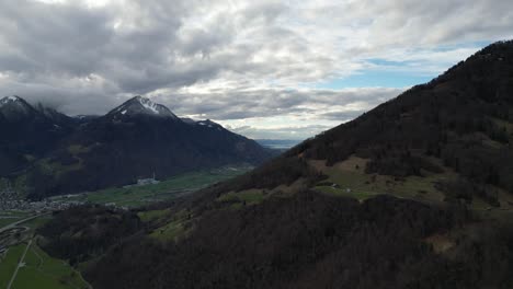 Establishing-pan-of-township-and-forested-ridgeline-with-epic-cloudy-overcast-sky