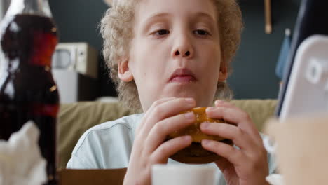 young boy eating a burger
