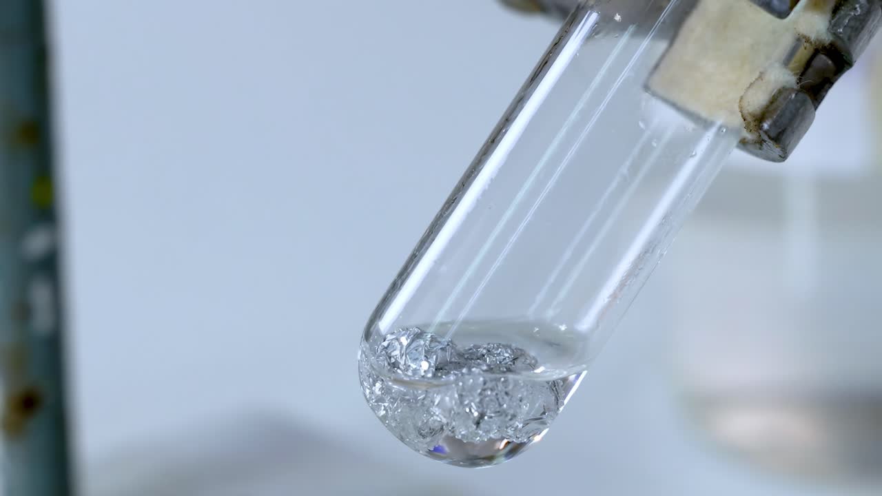 A detailed view of gas bubbles forming in a tilted test tube during a chemical reaction.