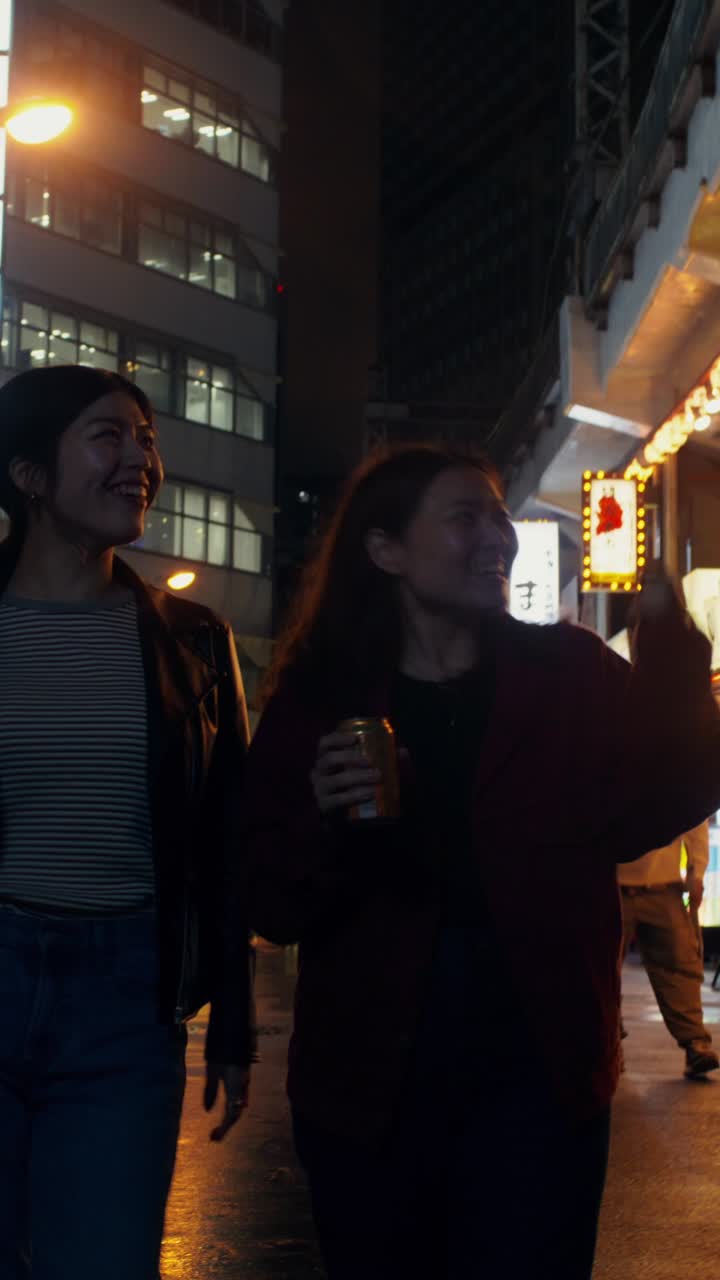 Two Women Walking at Night in a City