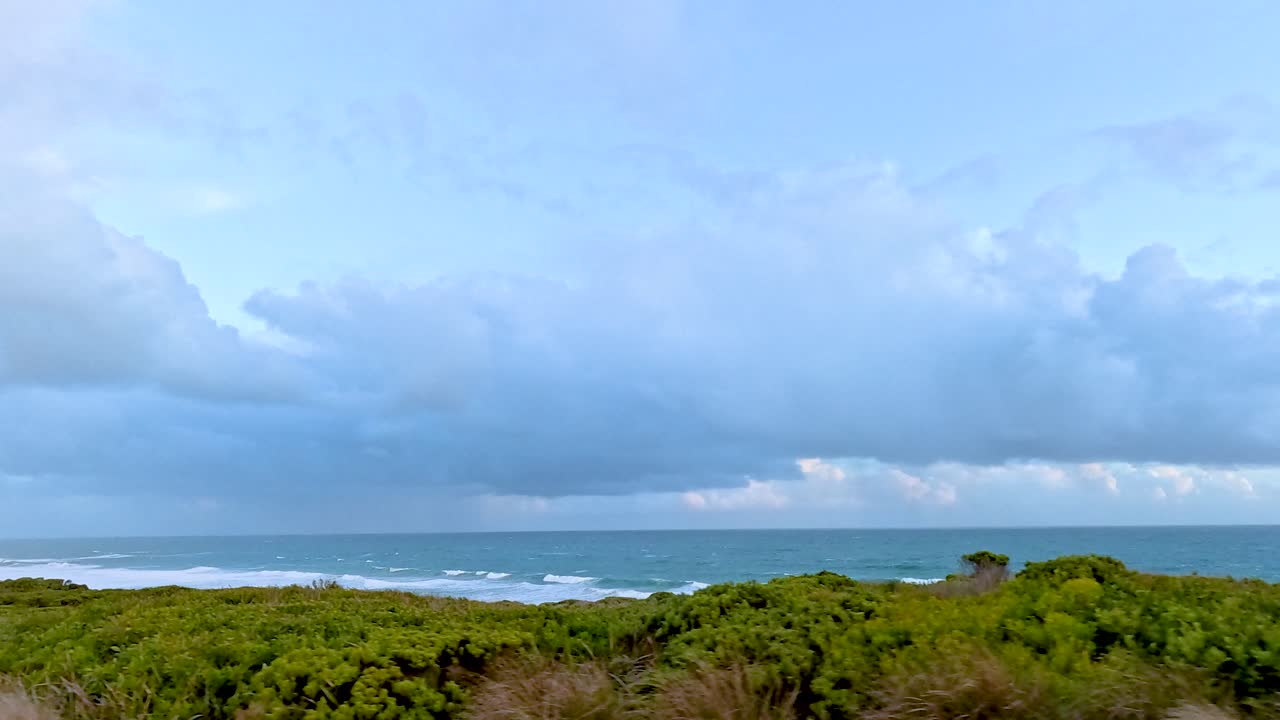 울창한 초록색과 넓은 바다 전망을 보여주는 조용한 드라이브 - 구름이 가득한 하늘 아래 - 오스트레일리아의 위대한 바다 도로를 따라