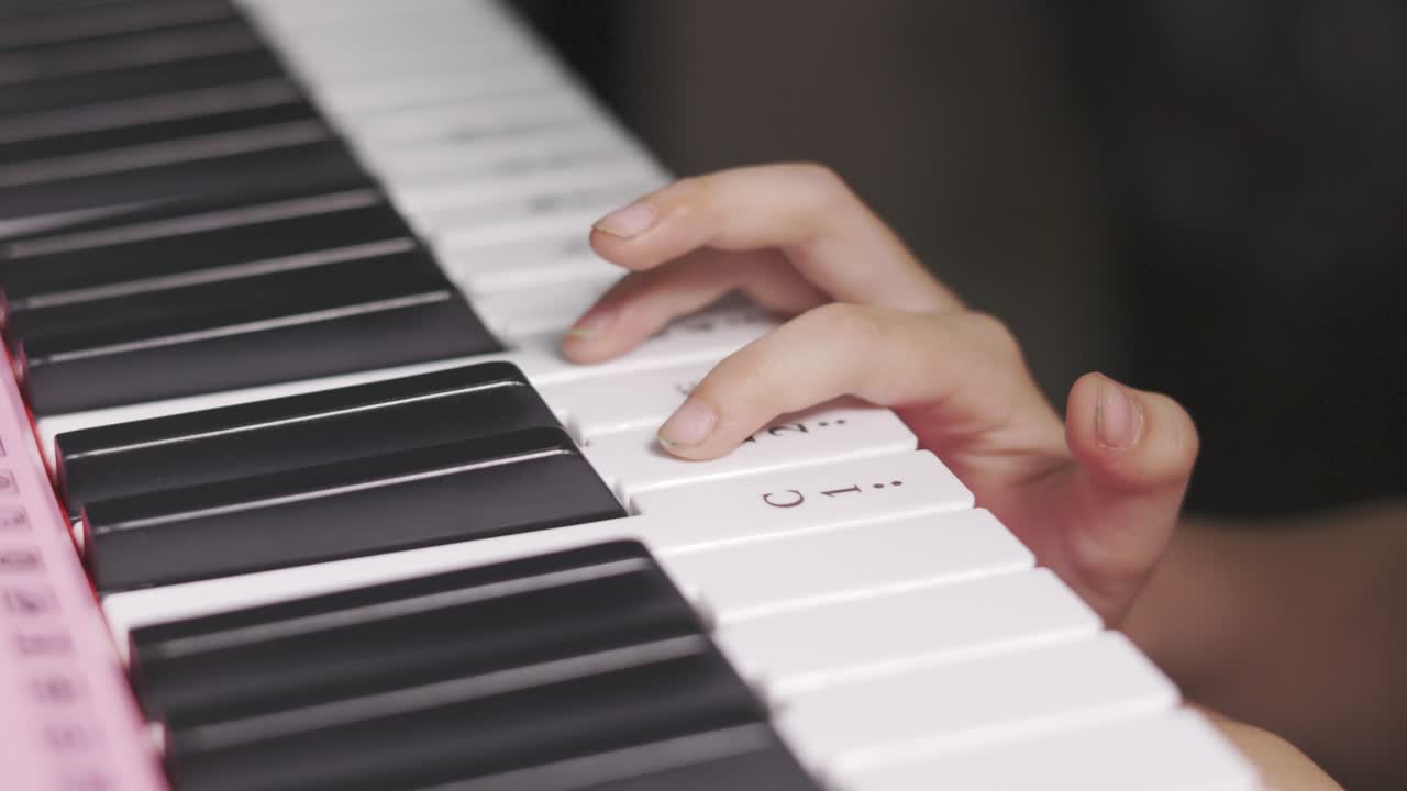 그녀의 취미와 여가 시간 활동을 위해 집에서 전기 키보드를 연주하고 연습하는 유치원 아이의 손과 손가락을 닫고 음악 수업을 시작합니다.