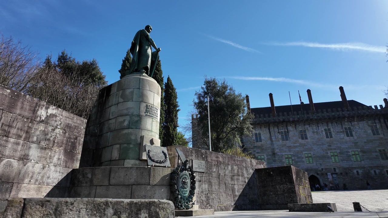 Guimaraes city monuments Dom Afonso Henriques statue on a sunny day. Gimbal shot with side movement.