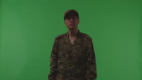 asian male soldier standing and looking around with serious facial expression to protects his country from the war on the green screen background