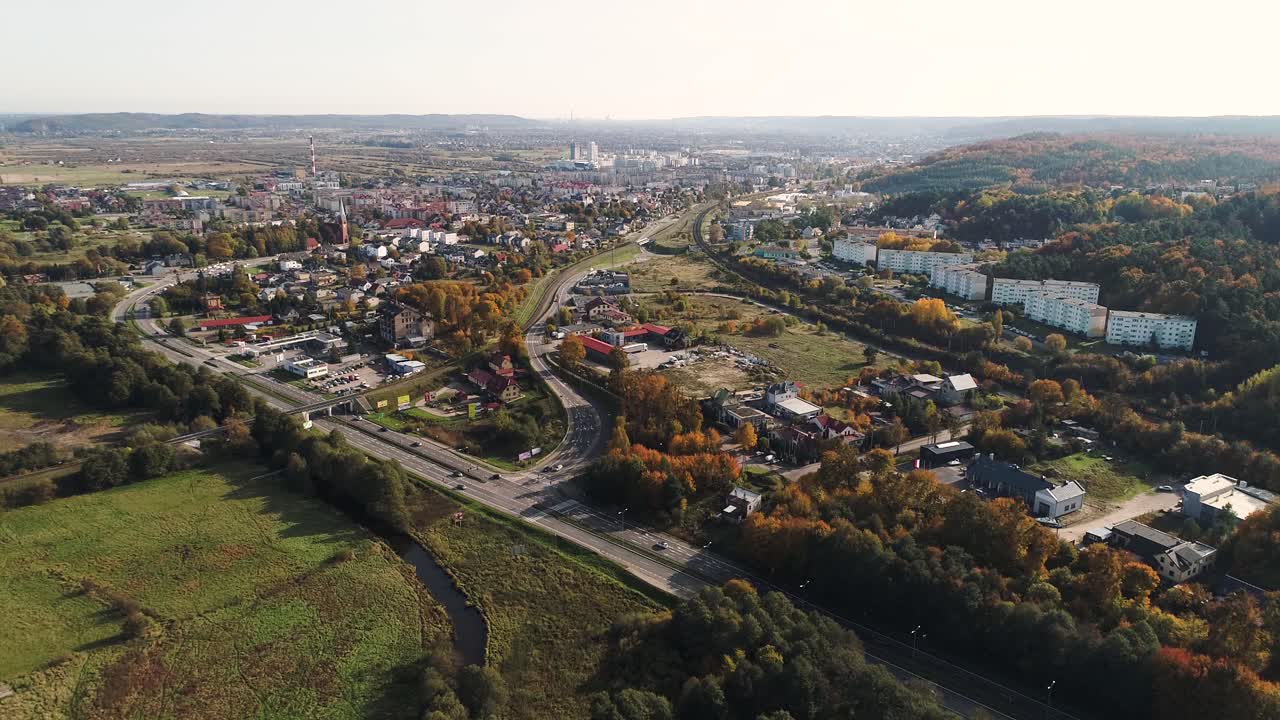 Ujęcie z drona głównej drogi międzymiastowej i wiaduktu kolejowego otoczonego polami.