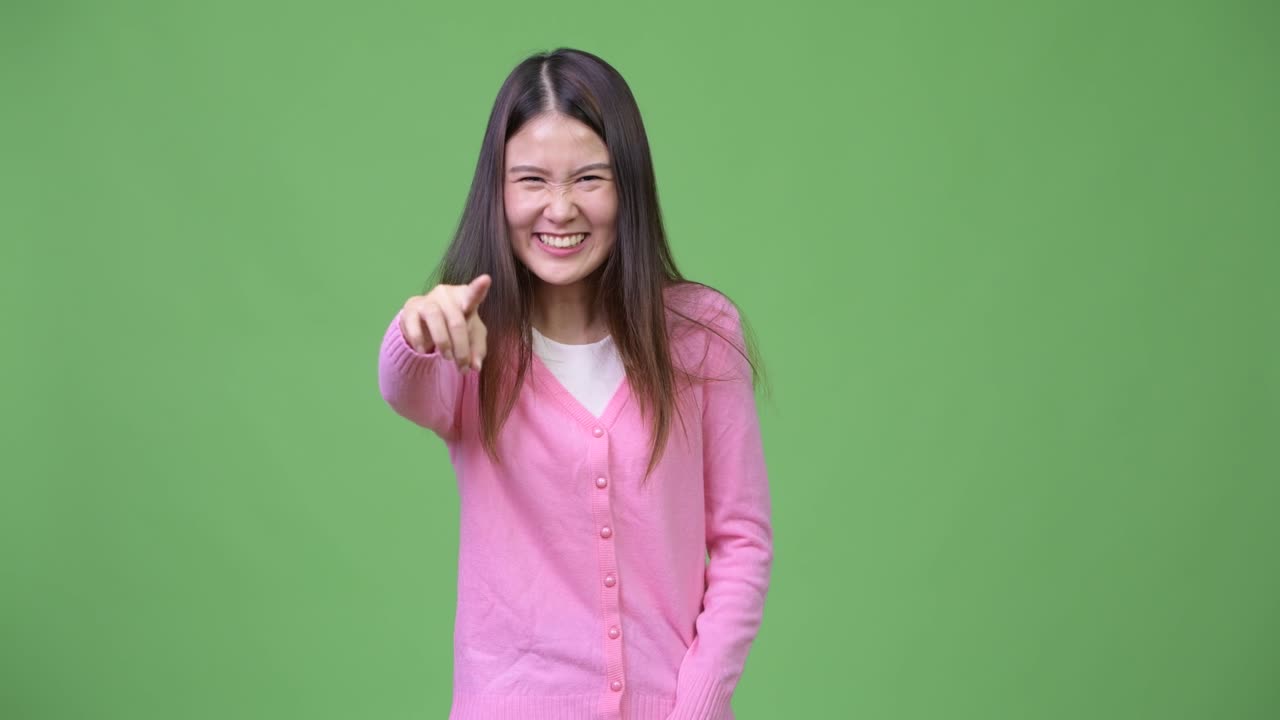 Ung, smuk asiatisk kvinde, der griner