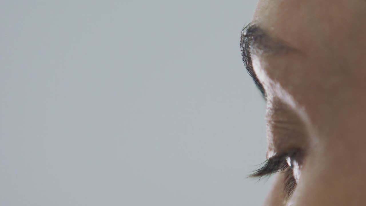 vista lateral de primer plano de la cara y el ojo de la mujer, parpadeando en cámara lenta