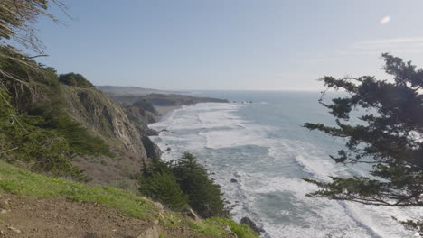 stacjonarne ujęcie od strony wzgórza z falami rozbijającymi się o brzeg plaży big sur california