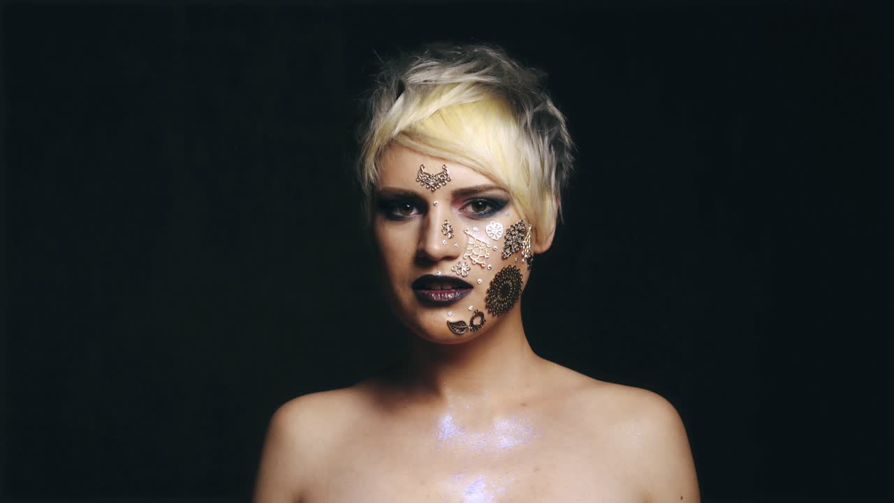Glamorøs kvinne med glitrende sminke. Portrett av en nydelig, glamorøs kvinne av kaukasisk opprinnelse, med kunstnerisk glitrende sminke og skuldre.