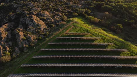 aerial of triangular shaped solar panel power station, tilt up reveals windmill