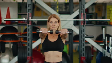 woman working out with dumbbells in gym