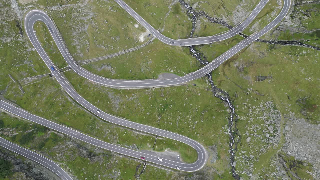 transagarasan gira en una carretera de montaña en los cárpatos, rumania, europa - aerial 4k birdseye