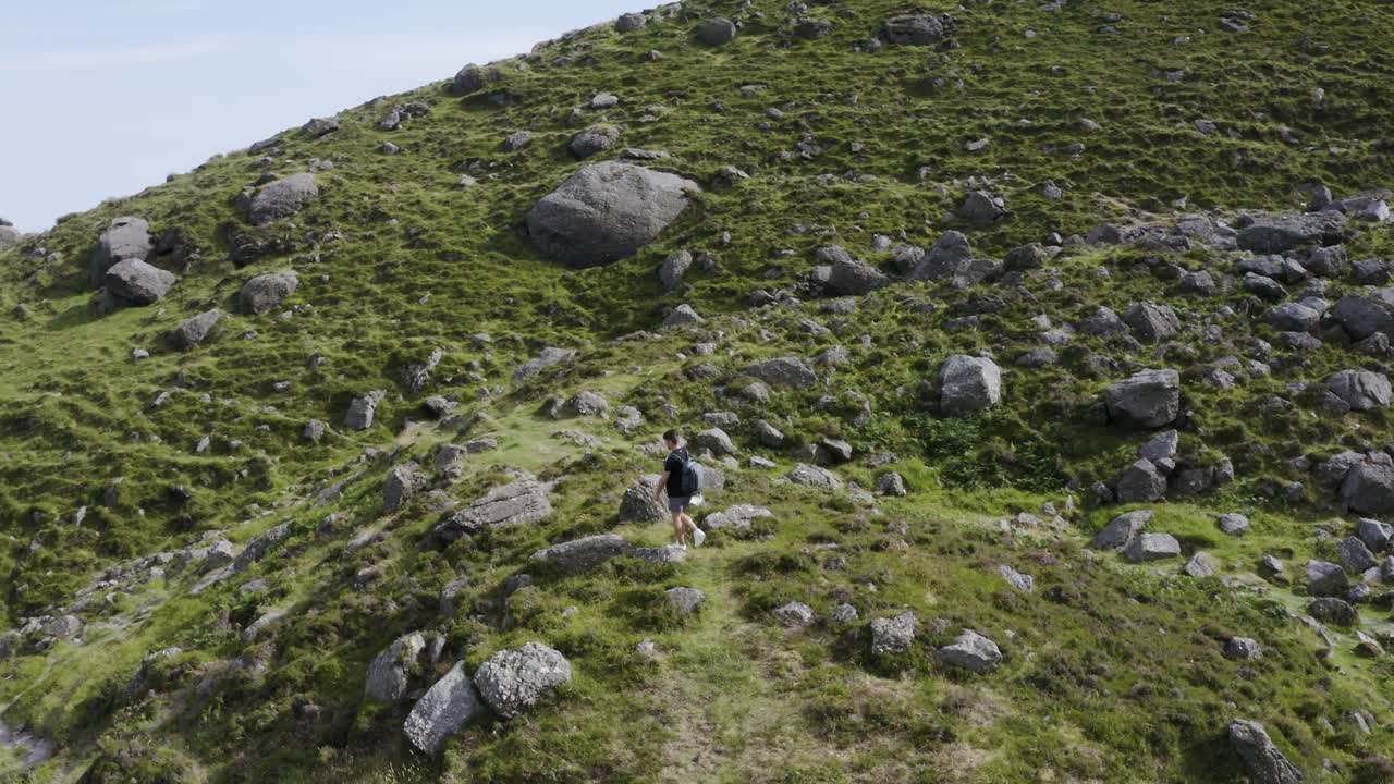Un drone sorvola un escursionista sul sentiero di montagna.