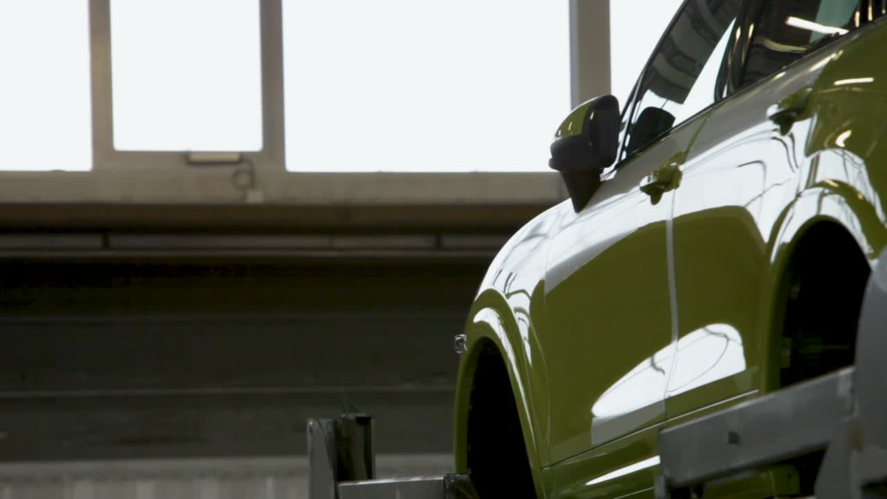 vista lateral de un coche verde lima en un garaje brillante, luz que fluye a través de las ventanas, vista parcial