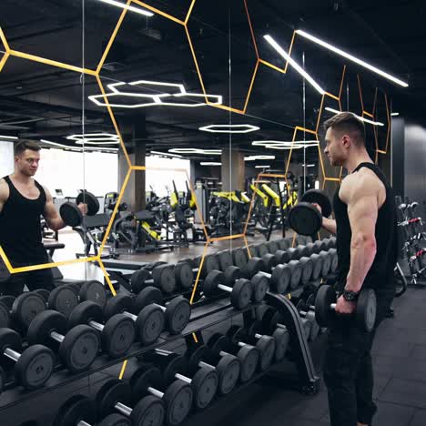 starting exercise with dumbbell weight. fit young man in sportswear focused on lifting dumbbells while exercising in the gym